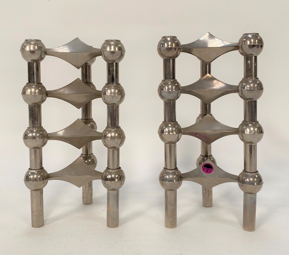 A pair of Stoff Nagel, nickel, four stacking, three section candlesticks, one with original paper