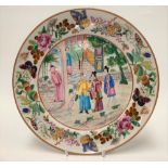 Chinese famille rose plate decorated with four figures within a garden setting, the rim decorated