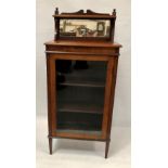 An early 20th century walnut cabinet, the top with open shelf and mirrored superstructure over a
