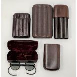 Three leather cigar cases, together with a cased pair of vintage spectacles (4).