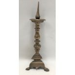 A 17th century bronze pricket candlestick with circular drip tray over a baluster turned column