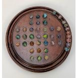A 19th century mahogany turned solitaire board with forty three glass marbles, diameter of board