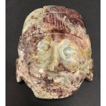 An ancient Mayan style carved red and grey marble mask, with old label to the back inscribed in