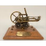 A modern brass scale model of Richard Trevithick's steam locomotive, a brass plaque to the wooden
