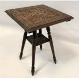 A carved teak two-tier occasional table, the top carved with a serpent amongst fruiting vine