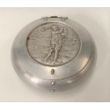 An aluminium ovoid pinch operated tobacco box, the hinged cover embossed with a golfer, diameter 7.