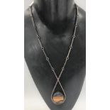 A good Danish silver Modernist design pendant necklace, the pendant set with a raw tigers eye core
