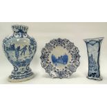 A Dutch delft blue and white baluster relief moulded vase, decorated to one side with three