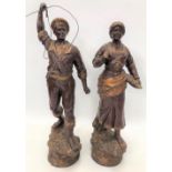 A pair of early 20th century bronzed spelter figures modelled as a sailor and a fish wife on a rocky