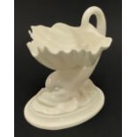 Royal Worcester blanc de chine salt modelled as a dolphin and shell, green printed marks to the