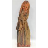 An early 20th century painted elm dummy board, depicting a young girl in a blue dress, signed