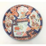A Japanese Imari charger painted with Samurai warriors and foliage within panels and with typical