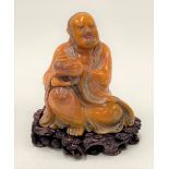 A Chinese Tianhuang carved figure of a seated figure of Lohan Buddha holding a censer, his robes