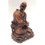 Chinese carved figure of a seated sage, a dog at his side, within original fitted stand, height 23cm