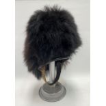A Grenadier Guards bearskin plume, upon aluminium hat stand.