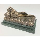A bronze figure of a reclining semi nude lady on a day bed, upon a stepped green marble base,