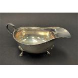 A George V silver sauce boat with beaded rim raised on triple outswept feet, maker T & J.P.,
