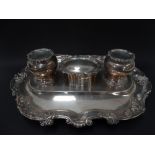 A good Edwardian silver desk stand by Carrington & Co., of oval lobed form, the rim foliate scroll