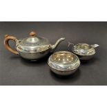 A George V silver three piece batchelor tea set by Charles and Richard Comyns, comprising a squat