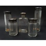A George V silver engine turned set of five silver lidded glass toilet jars, each London 1920,