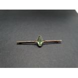 A 9ct. rose gold bar brooch set with a green cut stone, stamped 9ct., width 56mm approx., weight 2.