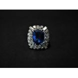 An attractive platinum diamond and sapphire cluster ring, the oval cut pale blue sapphire