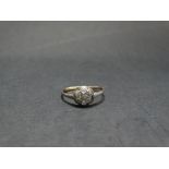 A 9ct. gold (tested) platinum set diamond seven stone cluster ring, the diamonds of 0.03ct. spread