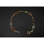 An attractive 18ct. gold stone set eight stone bracelet, set with an oval cut aquamarine, citrine,