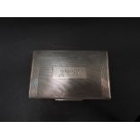 A George VI silver engine turned hinge lidded cigarette box with engraved monogram and dedication to