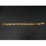 An attractive Edwardian 15ct. gold seed pearl set bracelet with fancy panel links set with two