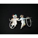 A French 900 silver and coloured enamel brooch in the form of an early 20th century girl and boy