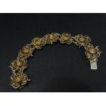 A white metal gilt filigree flowerhead bracelet with eight panels, two stamped marks, length 21.5cm,