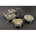 A George V silver three piece batchelor tea set, of ovoid wrythen fluted design, raised on triple