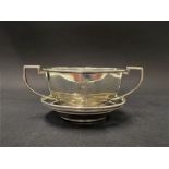 A George V silver twin handled pedestal bowl with engraved monogram upon circular stand, Birmingham