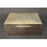 A silver rectangular hinge lidded cigarette box, width 14cm (hallmarks rubbed), weight overall 12.