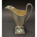 A George VI silver cream jug upon square pedestal base, maker E.V., Sheffield 1938, height 14cm,