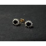 A pair of 9ct. hallmarked gold sapphire and diamond cluster stud earrings, the oval cut sapphire