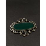 A green jadeite silver mounted brooch, the stone measures 40 x 14mm approx., weight 17.3g approx.
