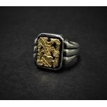 A Mexican silver gentleman's ring applied with an 18ct. gold Aztec style figure, the back of the