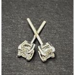 A pair of white metal diamond stud earrings, each diamond of 0.15ct. approx, weight 1g approx.