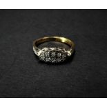 An 18ct. gold and platinum diamond set ten stone ring, the small illusion set diamonds each of 0.1ct