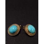 A pair of gold mounted turquoise cabachon set clip earrings, the oval turquoise measures 12 x 10mm