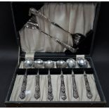 A George V silver weighted handle set of six dessert spoons and a pair of serving spoons with silver