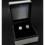 A pair of 18ct. white gold diamond stud earrings, the brilliant cut stones measuring with one of