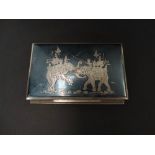 A Siam sterling silver niello decorated, hinge lidded cigarette box, the lid decorated with two