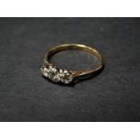 An 18ct. gold and platinum set diamond three stone ring, the central diamond of 0.15ct spread