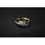 An 18ct. gold and platinum diamond three stone ring, the central diamond of 0.15ct. spread