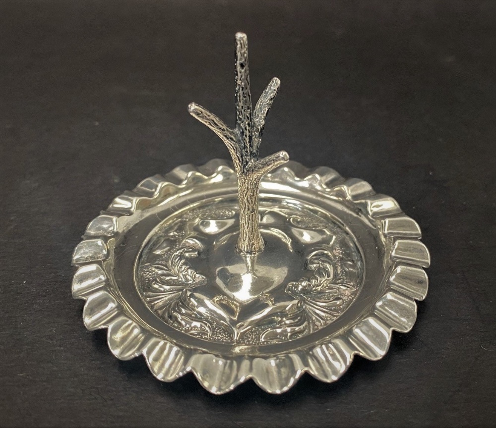 A George V silver ring tree with embossed shield decoration and wavy rim, maker James Dixon & Son,