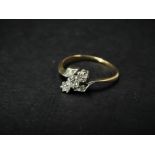 An 18ct. gold and platinum diamond set five stone crossover ring, the three central diamonds of 0.