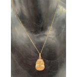 A 9ct. hallmarked gold pendant modelled as Tutankhamun's mask upon a 9ct. gold chain stamped 375,